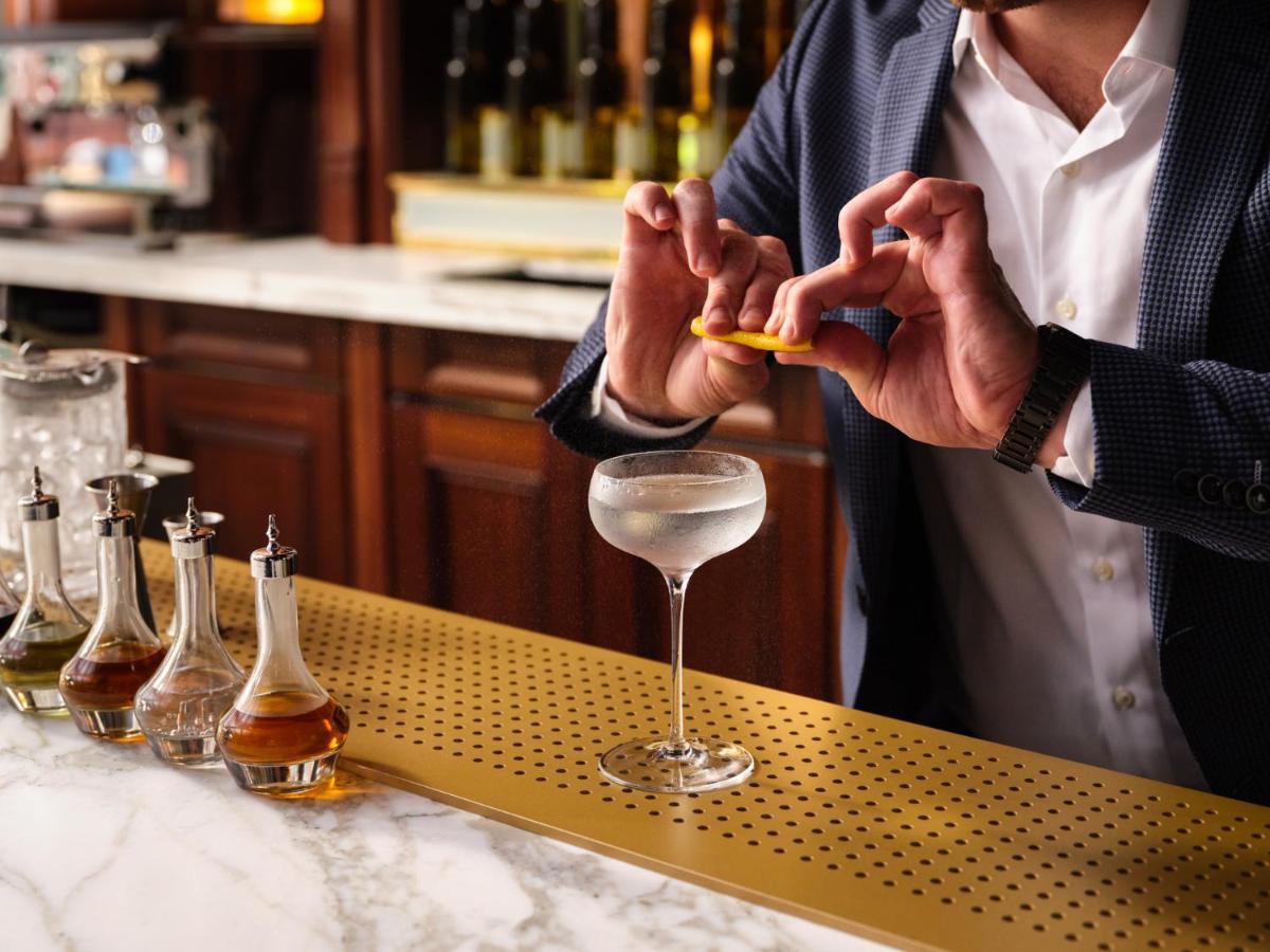 Hotel Nomad Londýn Exteriér fotografie A bartender adding a lemon twist to a Vesper cocktail